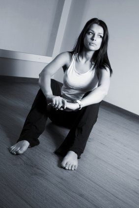 A girl with long black hair sitting on the floor